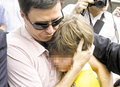 Sean (com rosto apagado) chega com o padrasto,<br>Joo Paulo Lins, ao consulado dos EUA no Rio