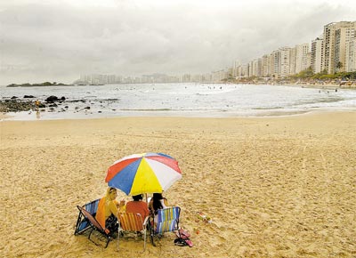 Banhistas na praia de Pitangueiras (Guaruj)<br>enfrentam a chuva fina do dia de Natal