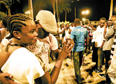 Haitianos danam para festejar o Natal, com caixa de som improvisada, na praa central de Brasileia, no Acre
