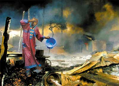Homem passa por destroos de exploso em oleoduto que matou 269 pessoas e deixou 60 feridas em Lagos (Nigria)