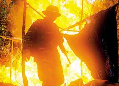 <b>Trfico na fronteira</b>: Soldado diante de laboratrio de pasta de cocana incendiado pelo Exrcito boliviano, na regio de Chapare