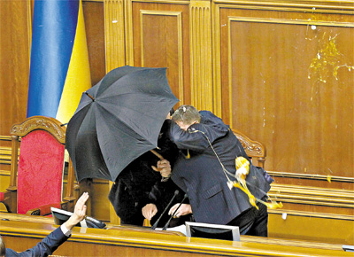 <b>INDECORO PARLAMENTAR:</b> Seguranas tentam proteger Volodimir Litvin, presidente do Parlamento da Ucrnia, de chuva de ovos