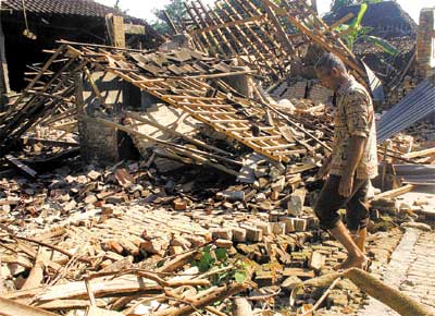 Morador de Java caminha sobre escombros aps terremoto na Indonsia que deixou ainda 2.900 feridos e 200 mil desabrigados