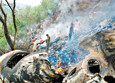 <b>DESTROOS:</b> Paquistaneses buscam corpos de vtimas da queda de Airbus perto de Islamabad; com 152 mortos, acidente foi o pior do pas