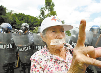 Yolanda Chavarria, 80, participa de manifestao a favor de Zelaya diante de soldados da polcia nacional de Honduras, em Tegucigalpa