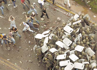 Apoiadores do presidente deposto de Honduras, Manuel Zelaya,<br>enfrentam militares diante da sede do governo em Tegucigalpa