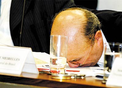 O presidente do Banco Central, Henrique Meirelles, bate com o rosto na mesa ao fazer alongamento durante audincia no Senado