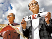 Wakita e Tokudome com bandeira e faixa da poca