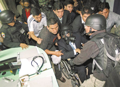 De mscara e em cadeira de rodas, Rafael Correa, presidente do Equador, deixa hospital para voltar a palcio do governo