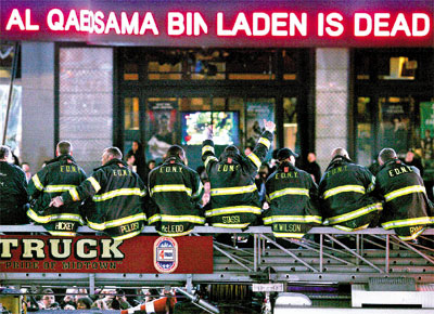 Na Times Square,em Nova York (EUA), bombeiros festejam<br>noticirio que anuncia a morte do terrorista no Paquisto