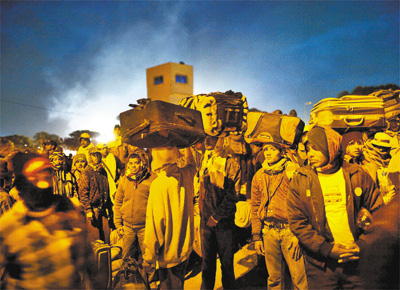 Em fuga, cidados de Bangladesh que trabalhavam na Lbia esperam nibus na cidade fronteiria de Ras Jedir (Tunsia)