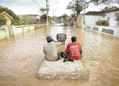 <b>A CU ABERTO: </b>Moradores de Eldorado (SP) usam mveis estragados pela gua para simular uma sala de estar em rua inundada pela cheia do rio Ribeira de Iguape