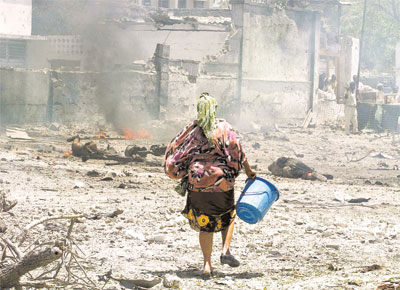 Uma mulher somali que, com um balde, tentava apagar o fogo dos corpos calcinados chamou ateno na cena do atentado terrorista que matou mais de 70 em Mogadcio
