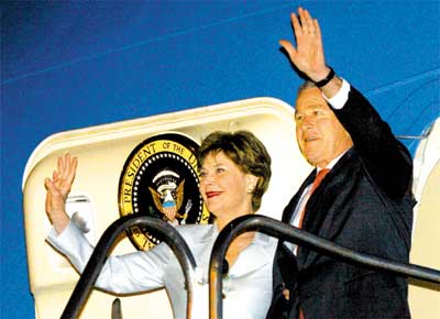 O presidente George W. Bush e a primeira-dama Laura Bush acenam ao desembarcar em SP