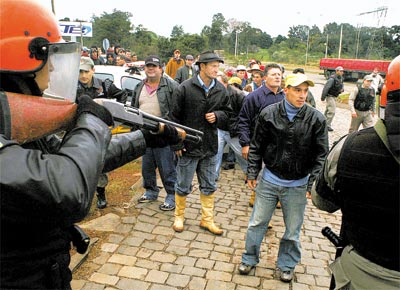 Soldados da Brigada Militar apontam armas para invasores da fbrica da Bunge no RS, em ao na qual 5 sem-terra foram feridos