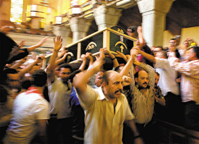 No Cairo, cristos coptas carregam um dos ao menos 25 mortos nos choques entre as foras de segurana do Egito e a minoria religiosa