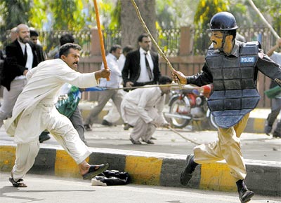Policial e manifestante lutam em Lahore durante um protesto contra o governo paquistans, que ordenara a priso de lderes da oposio