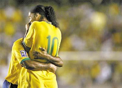 Ronaldinho (de costas) abraa Vgner Love, autor do 1 gol do Brasil nos 5 a 0 sobre o Equador