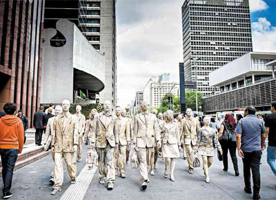 <b>NA LAMA: </b>Vestidos como executivos e cobertos por cinco quilos de argila cada um, atores participam de performance na avenida Paulista para protestar contra o que os manifestantes chamaram de 'aprisionamento do trabalho'