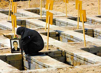 Libanesa chora ao lado de uma das tumbas de vtimas do ataque de Israel a Qana, no sul do pas, no dia 30 de julho