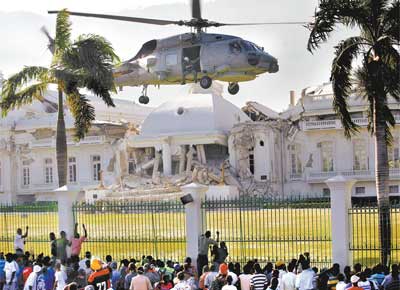 Em Porto Prncipe, helicptero dos EUA prepara-se para pousar<br> nos jardins do palcio presidencial, que foi destrudo pelo tremor