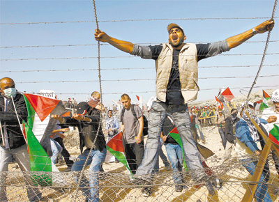 <b>VOZ CONTRA A BARREIRA:</b> Manifestante grita na barreira construda por Israel que corta ao meio a aldeia palestina de Bilin (Cisjordnia)