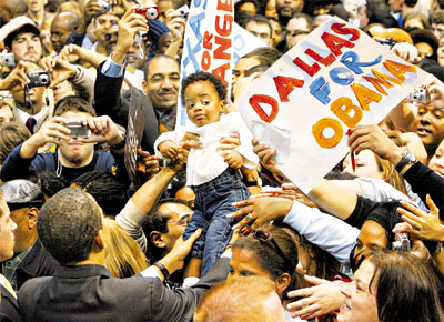 Barack Obama (de costas) segura criana durante campanha em Dallas