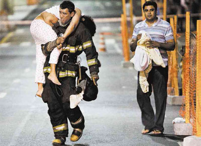 Bombeiro carrega mulher que passou mal aps vazamento de gs,<br>de madrugada, na rua Amaral Gurgel, centro de So Paulo