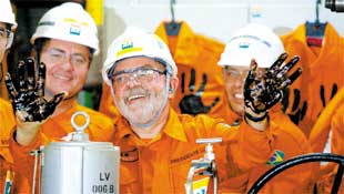 O presidente Lula exibe as mos sujas de petrleo cru aps acionar uma das vlvulas da plataforma P-50 da Petrobras