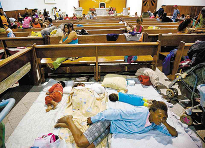 Crianas dormem em colches espalhados na igreja que foi transformada em abrigo aps a desocupao de terreno