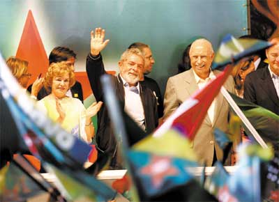 Em conveno petista, o presidente Lula acena para partidrios entre a mulher, Marisa, e o seu candidato a vice, Jos Alencar.