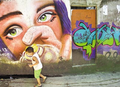 Garoto passa por grafite no morro Pavão-Pavãozinho