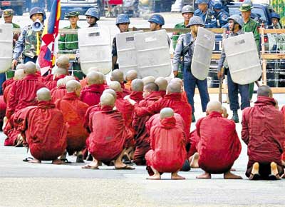 Monges budistas sentam-se em protesto em Yangun, capital de Mianmar; no 9 dia de atos contra a junta que governa o pas h 45 anos