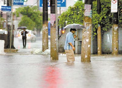 Pedestre com gua na altura dos joelhos no bairro da Sade, zona sul de So Paulo, uma das regies mais prejudicadas pela chuva de ontem