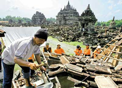 <B>4611 MORTOS</B> Trabalhadores removem destroos diante de um templo na ilha indonsia de Java, aps terremoto que atingiu o local no sbado