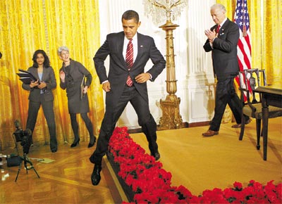 Observado por seu vice, Barack Obama passa por cima de flores para cumprimentar pessoas que assistiam a evento na Casa Branca